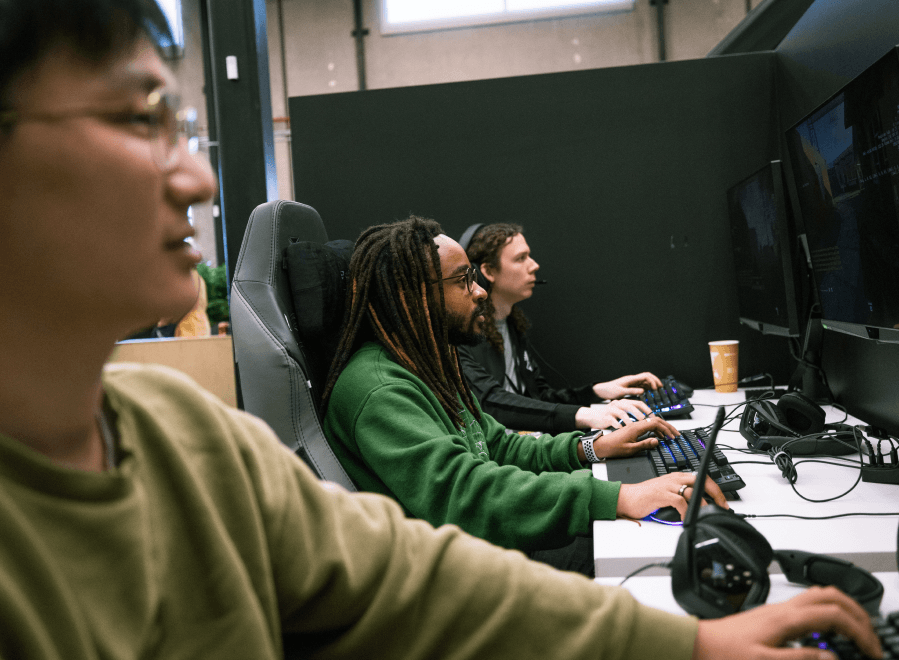 Three Treyarch employees sitting side by side looking at large computer monitors